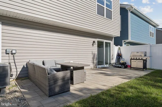 a view of a patio with a table and chairs and a barbeque