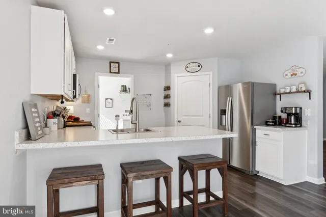 a kitchen with stainless steel appliances granite countertop a refrigerator and a stove top oven