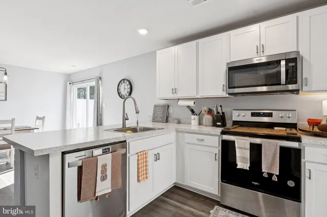 a kitchen with stainless steel appliances granite countertop a stove a sink and a microwave
