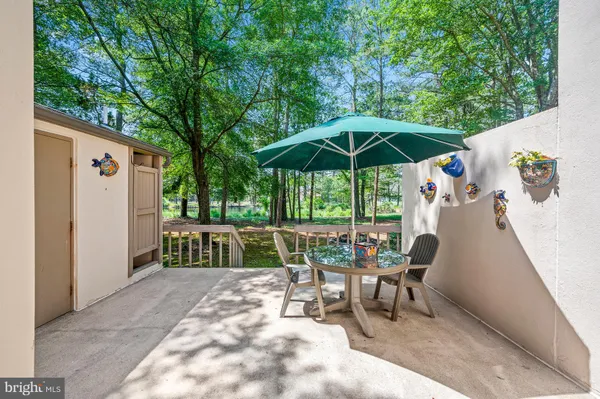 a view of a patio with a table and chairs under an umbrella