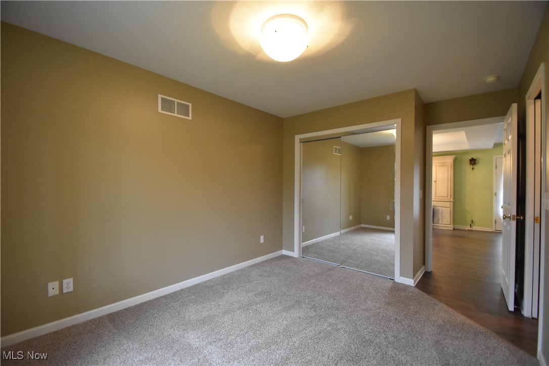 603 South Raccoon Road, Unit 49 Youngstown, OH 44515 - Photo 19 of 27 Unfurnished bedroom with a closet, baseboards, visible vents, and dark carpet