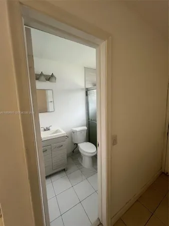 a bathroom with a granite countertop toilet and a sink