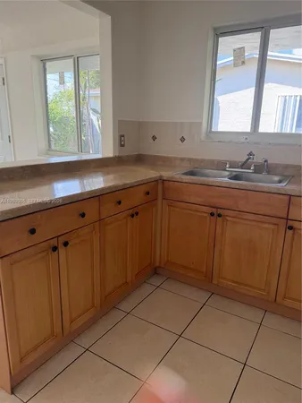a kitchen with a sink window and cabinets