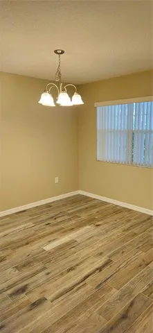 a view of a room with a window and wooden floor