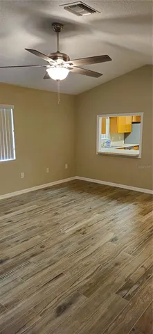 a view of a room with wooden floor and chandelier