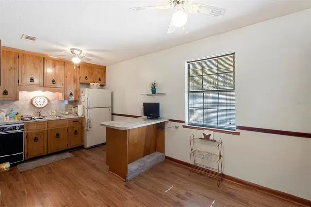 a kitchen with stainless steel appliances granite countertop a stove refrigerator and cabinets