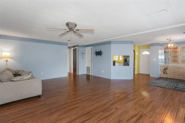a view of a livingroom with wooden floor and a ceiling fan
