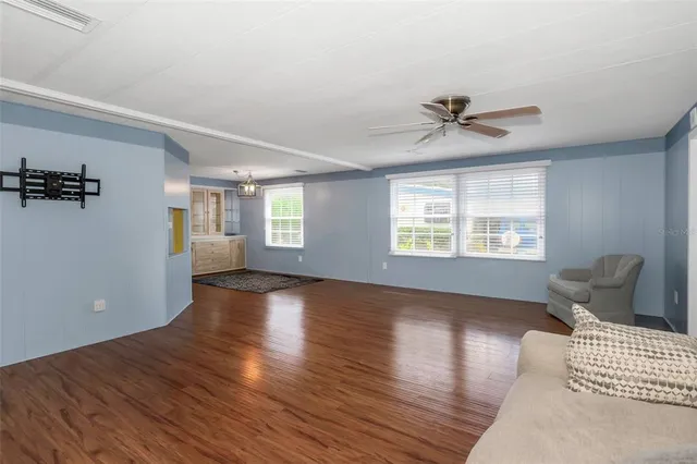 a view of an empty room with a window and wooden floor