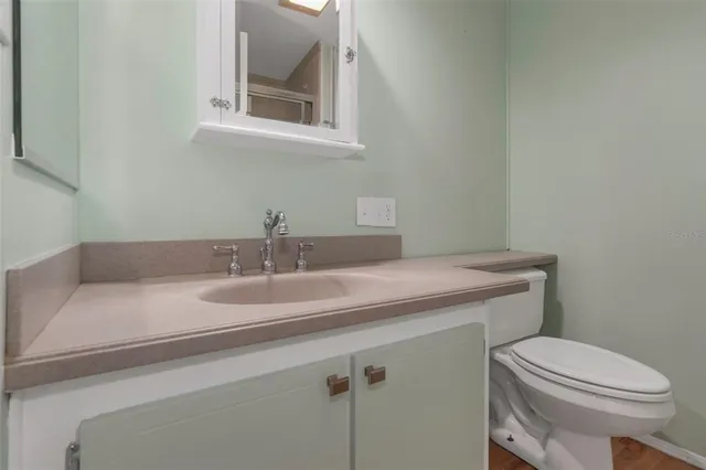a bathroom with a granite countertop toilet sink and mirror
