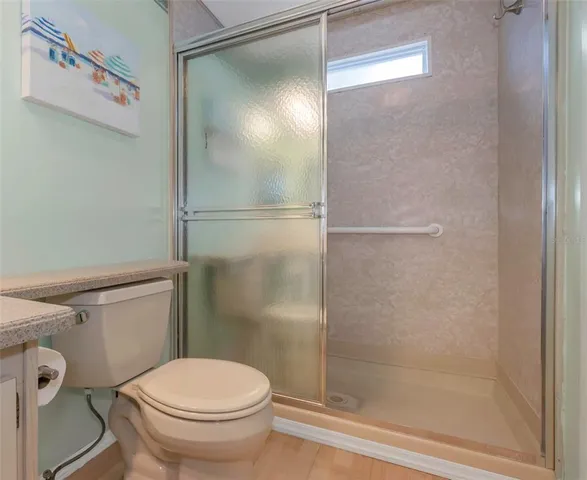 a white toilet sitting next to a shower