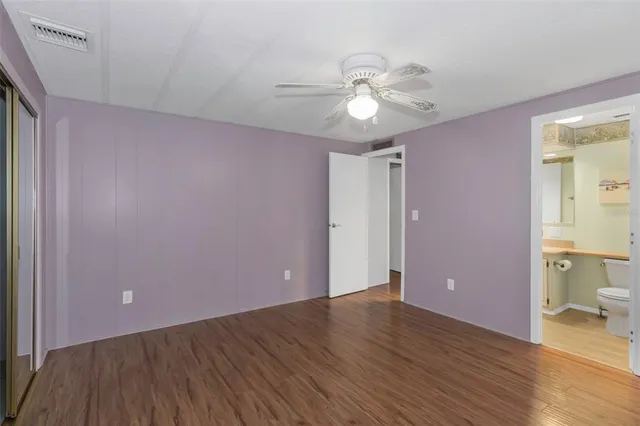 a view of a livingroom with wooden floor and a bathroom