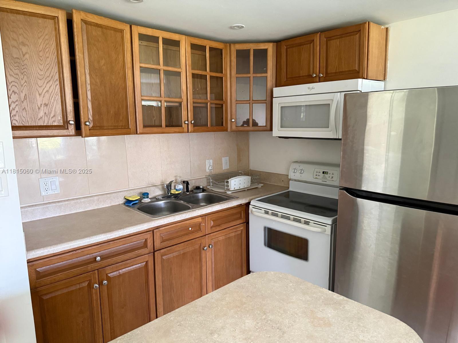 217 Suffolk F, Unit 217 Boca Raton, FL 33434 - Photo 2 of 11 a kitchen with stainless steel appliances granite countertop a refrigerator sink and stove