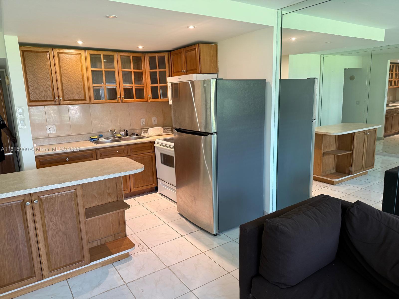 217 Suffolk F, Unit 217 Boca Raton, FL 33434 - Photo 4 of 11 a kitchen with stainless steel appliances granite countertop a refrigerator and a stove top oven