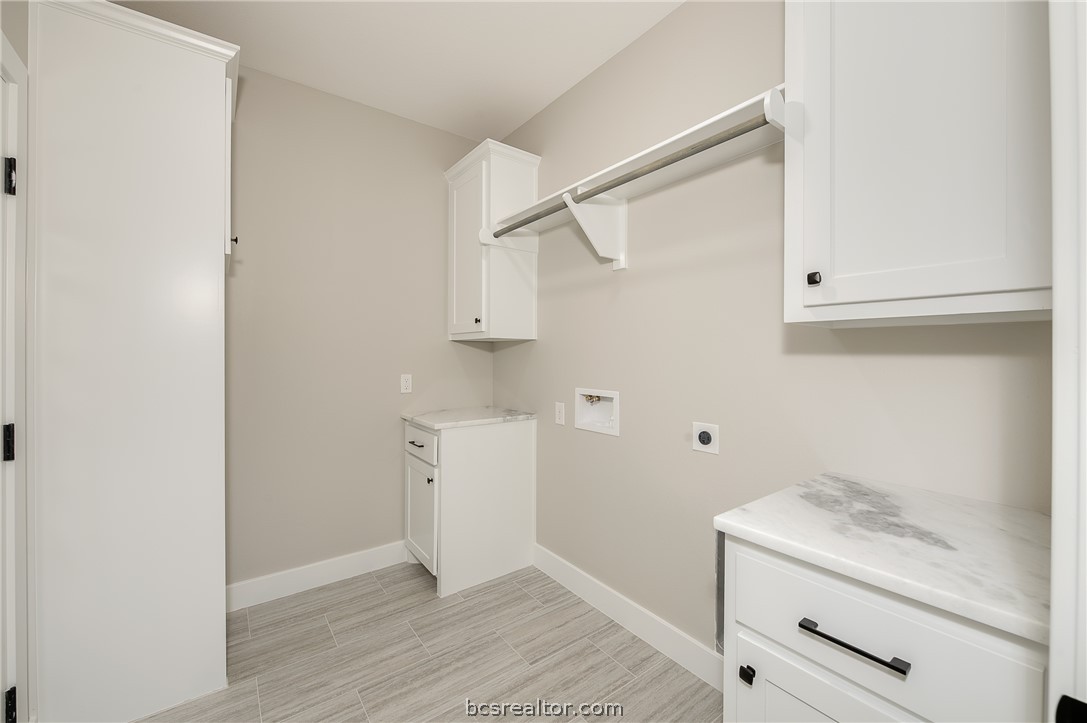 2908 GOLDBERG Drive Bryan, TX 77808 - Photo 12 of 44 Utility room features storage cabinets, drying rod and vinyl flooring.