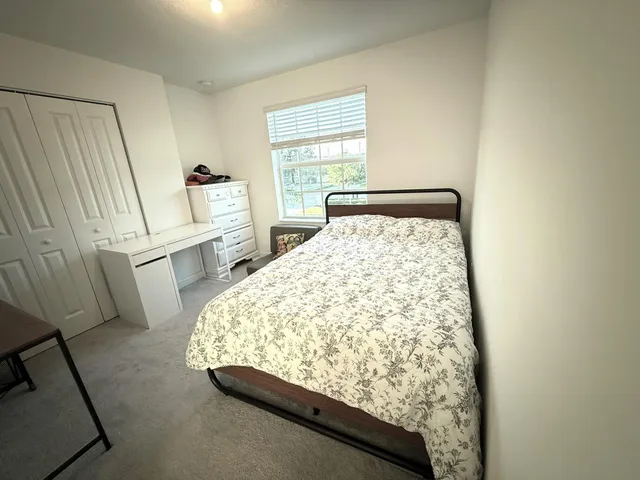 a bed sitting in a bedroom next to a window