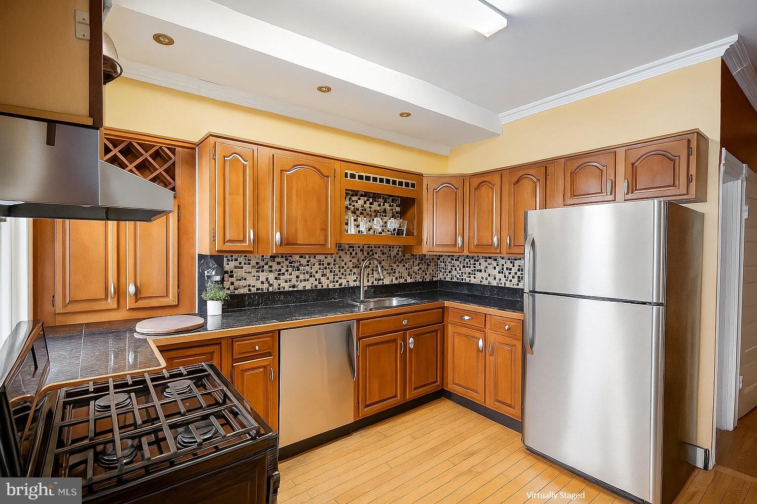 2425 West North Avenue Baltimore, MD 21216 - Photo 2 of 7 a kitchen with stainless steel appliances granite countertop a refrigerator stove sink and cabinets