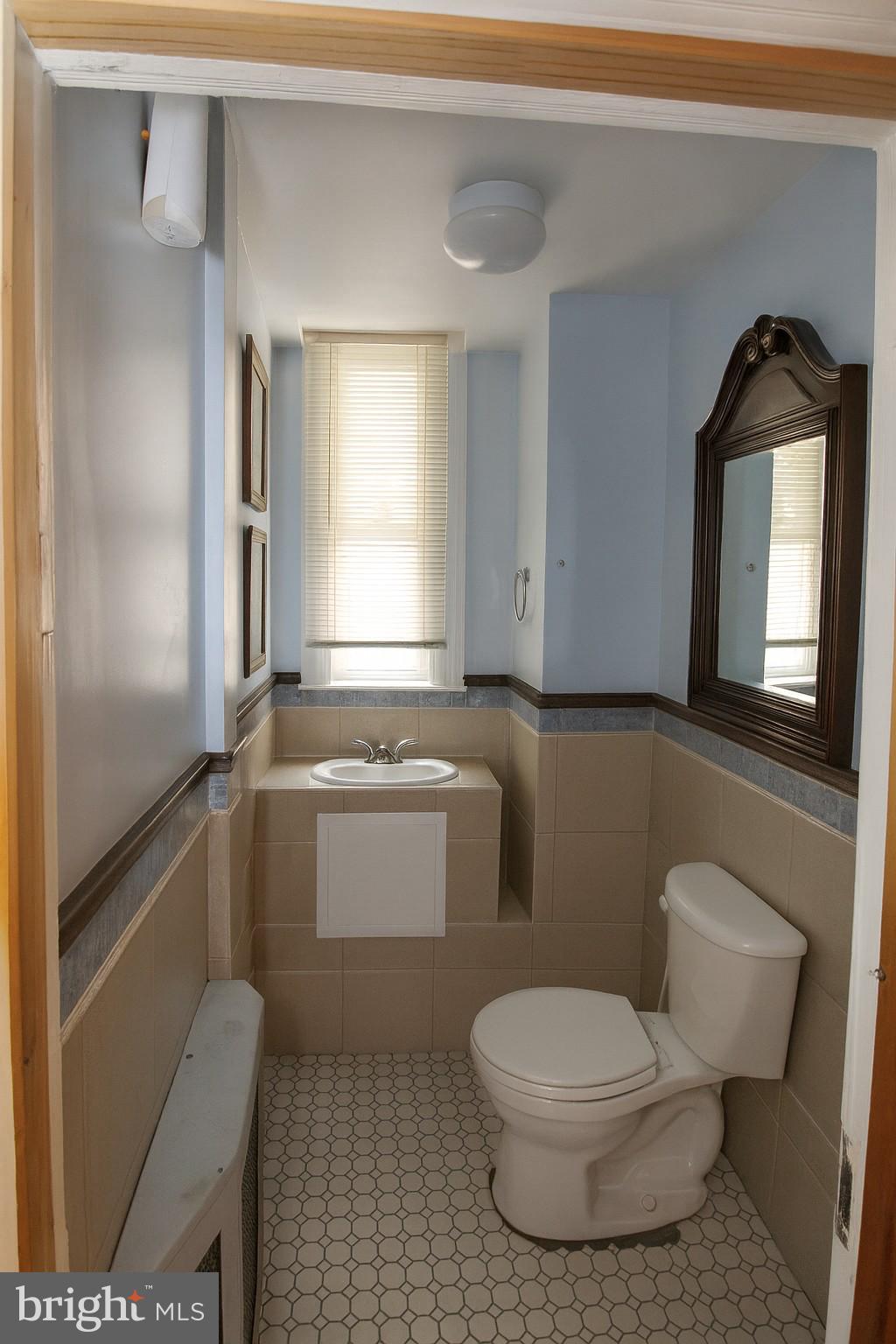 2425 West North Avenue Baltimore, MD 21216 - Photo 4 of 7 a bathroom with a toilet sink and mirror