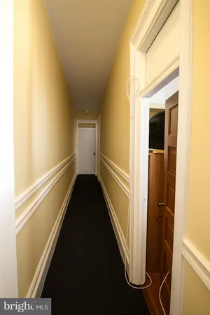 a view of a hallway with wooden floor and stairs