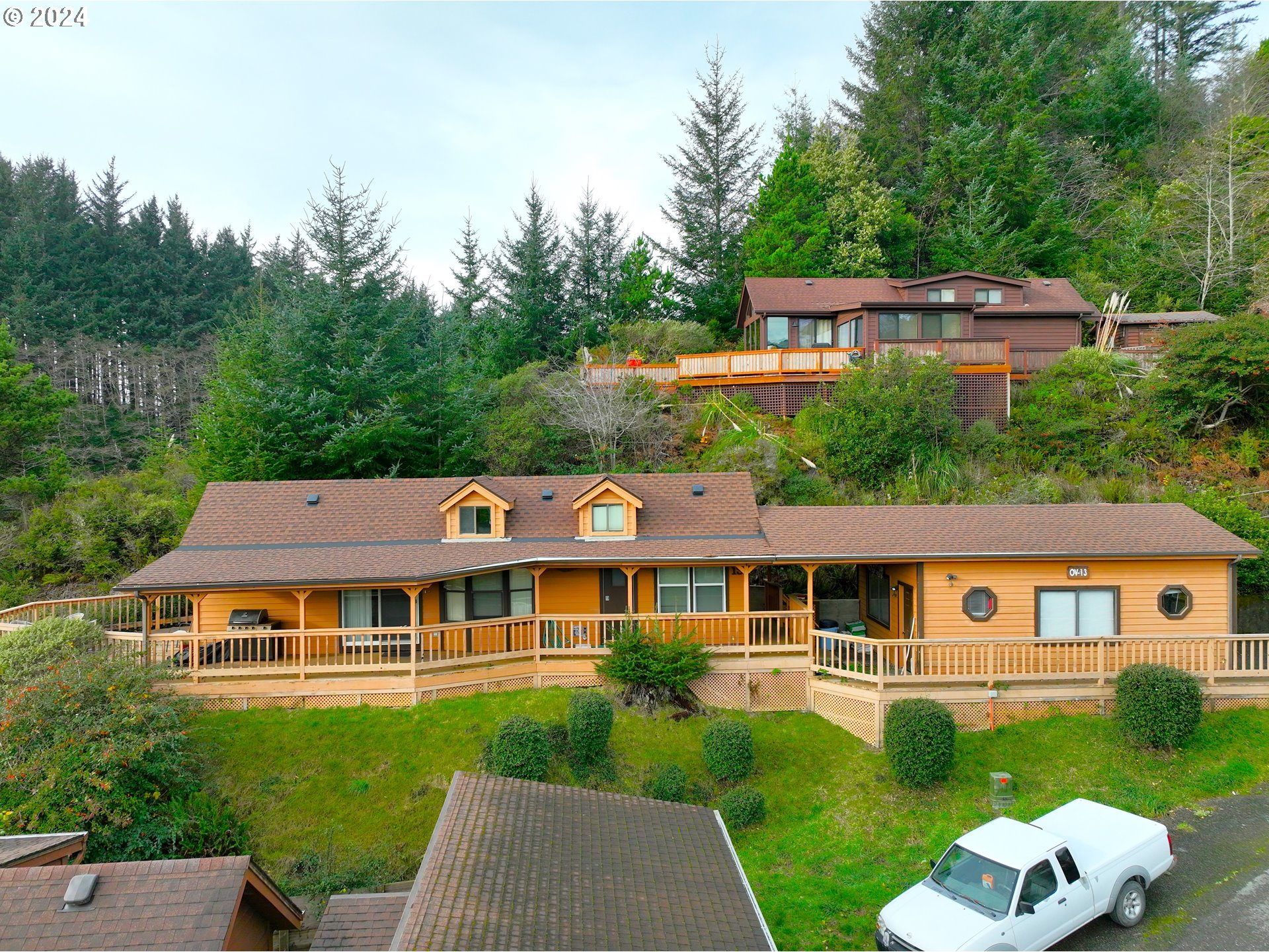 19921 Whaleshead Road, Unit OV13 Brookings, OR 97415 - Photo 2 of 43 a front view of a house with a yard table and chairs