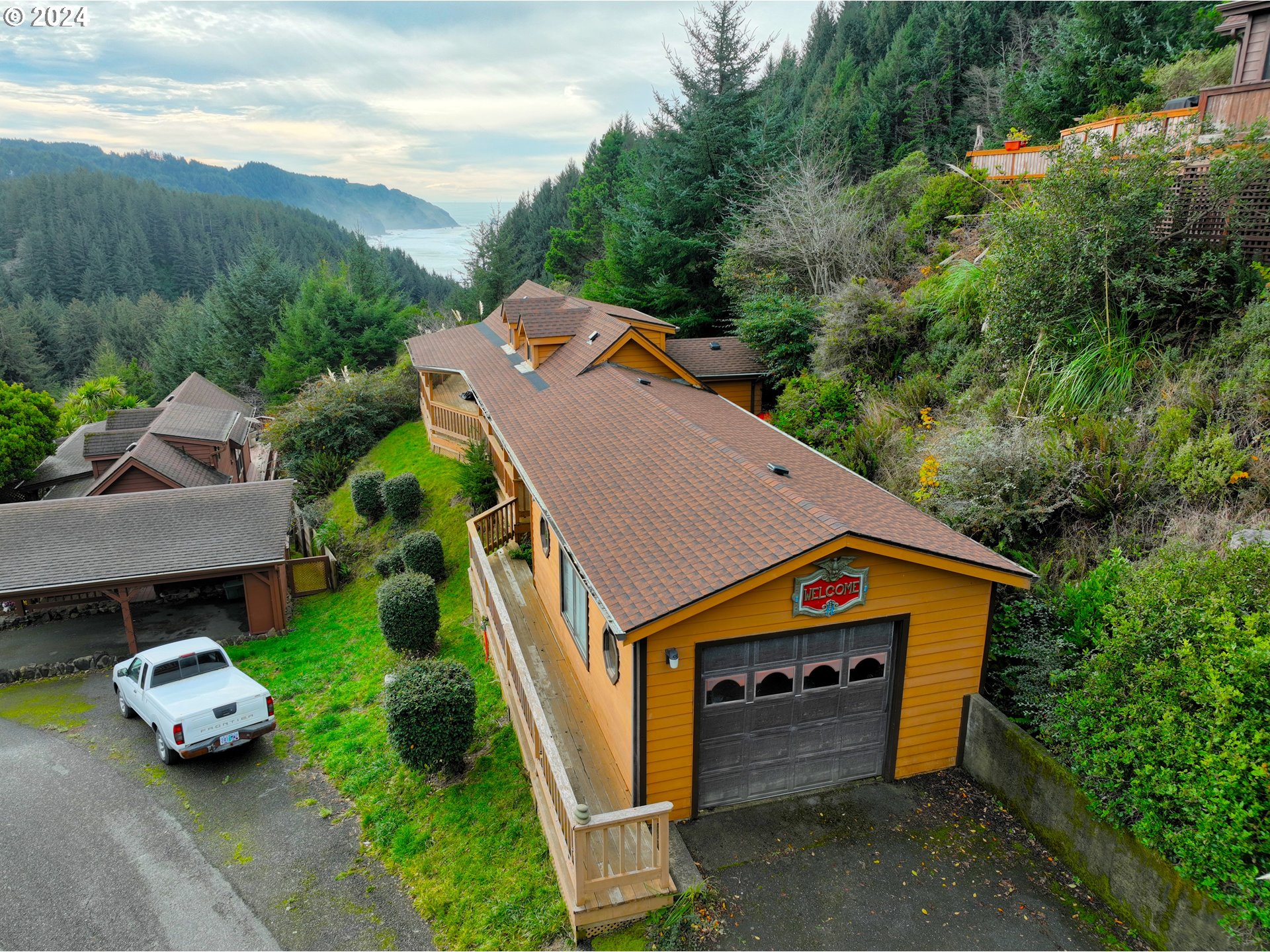 19921 Whaleshead Road, Unit OV13 Brookings, OR 97415 - Photo 4 of 43 an aerial view of a house with a garden and parking space