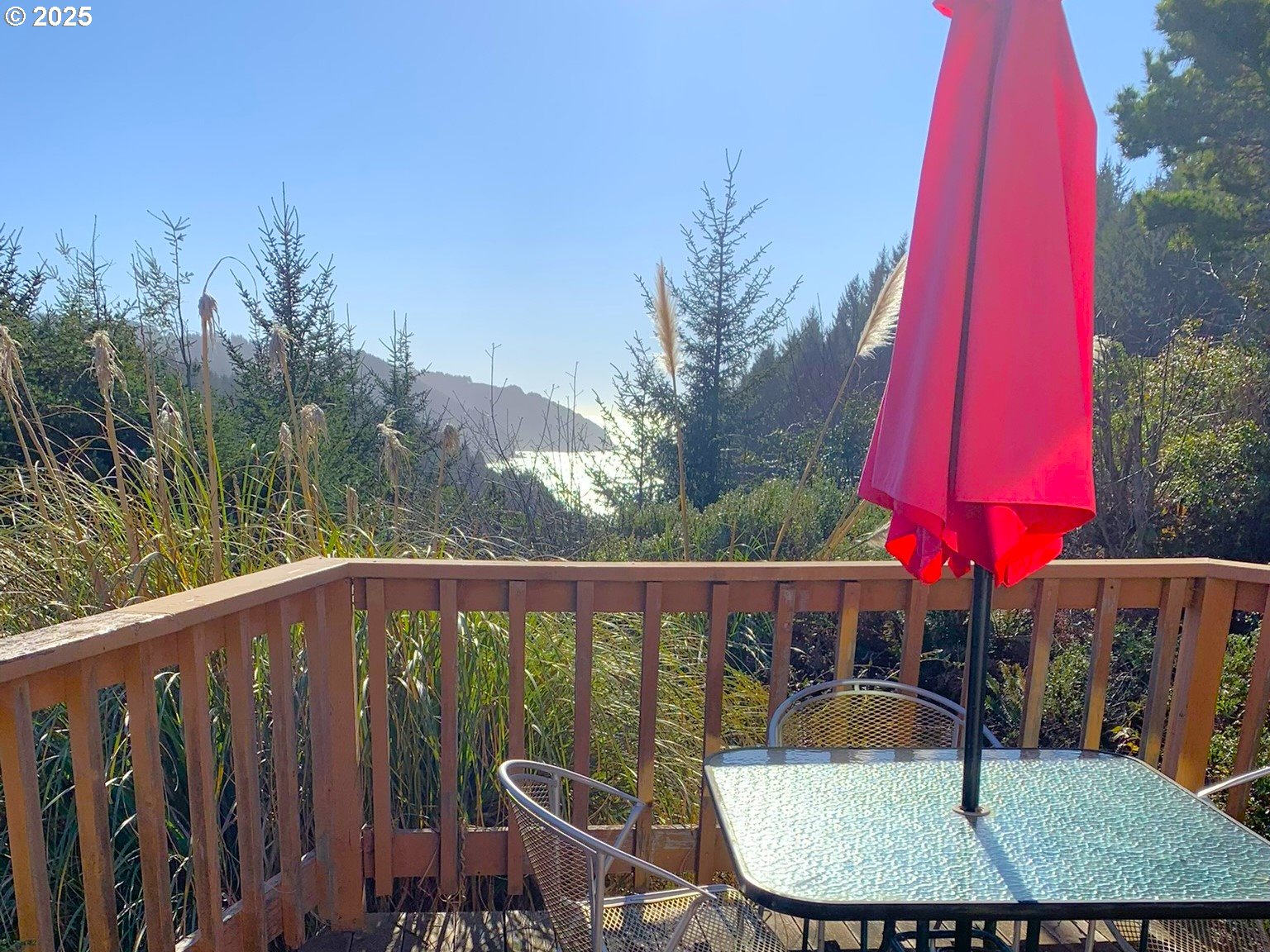19921 Whaleshead Road, Unit OV13 Brookings, OR 97415 - Photo 5 of 43 a balcony with wooden floor table and chairs