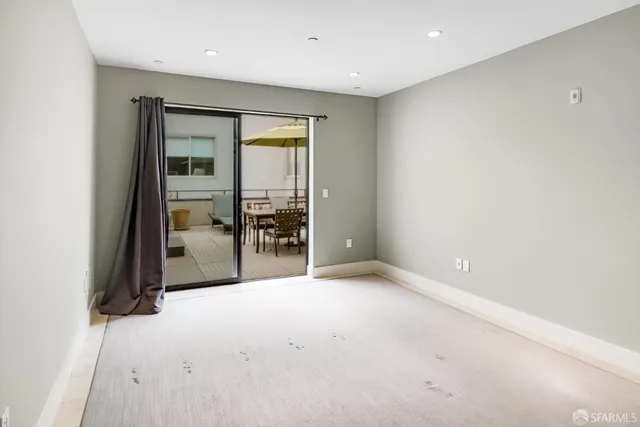 an empty room with floor to ceiling window and glass door