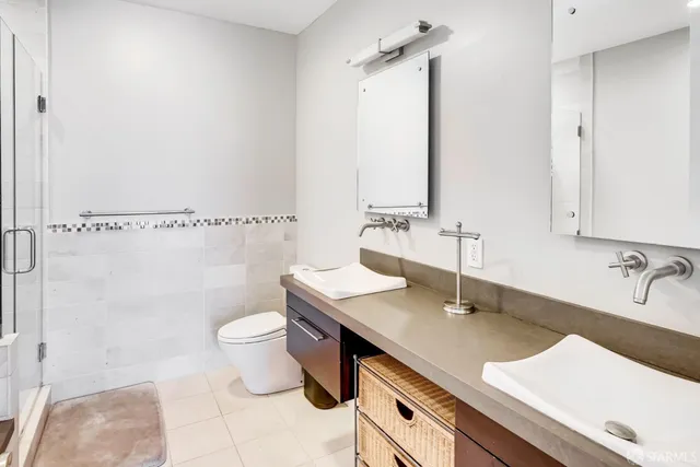 a bathroom with a sink a toilet and shower