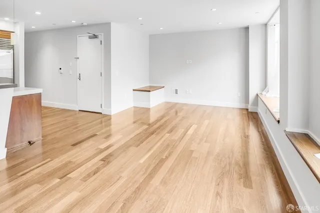 a view of an empty room with wooden floor