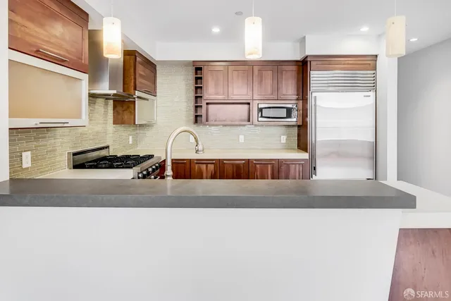 a kitchen with kitchen island a counter top a stove and a refrigerator