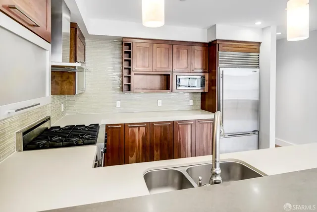 a kitchen with a refrigerator a sink and wooden cabinets
