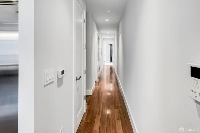 a view of a hallway with wooden floor