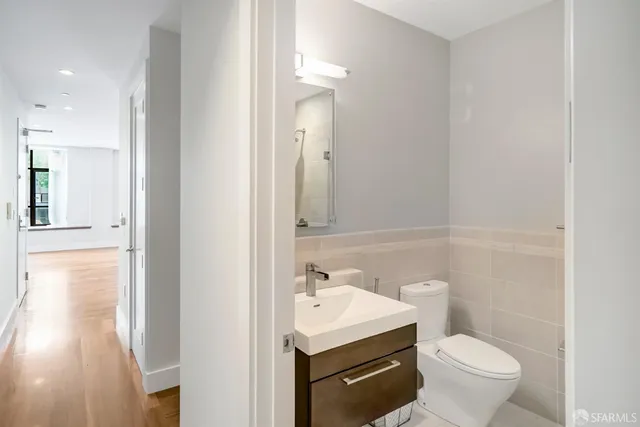 a bathroom with a sink a toilet a mirror and vanity