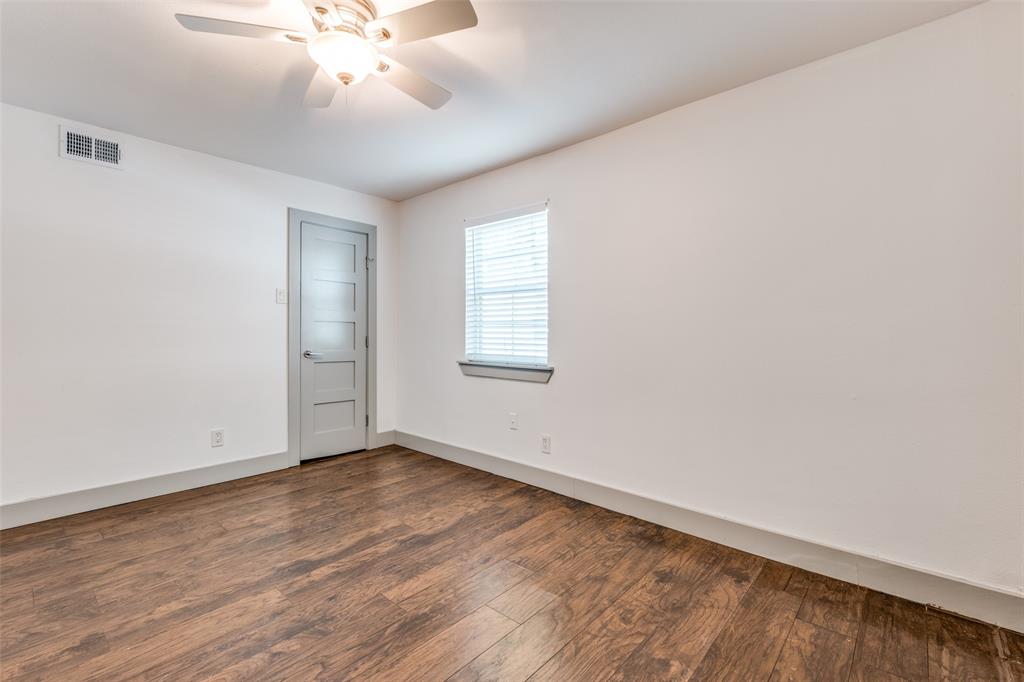 4633 Fairmount Street, Unit 109 Dallas, TX 75219 - Photo 12 of 14 Spacious room featuring wood-finish flooring, white walls, and a modern ceiling fan with integrated lighting