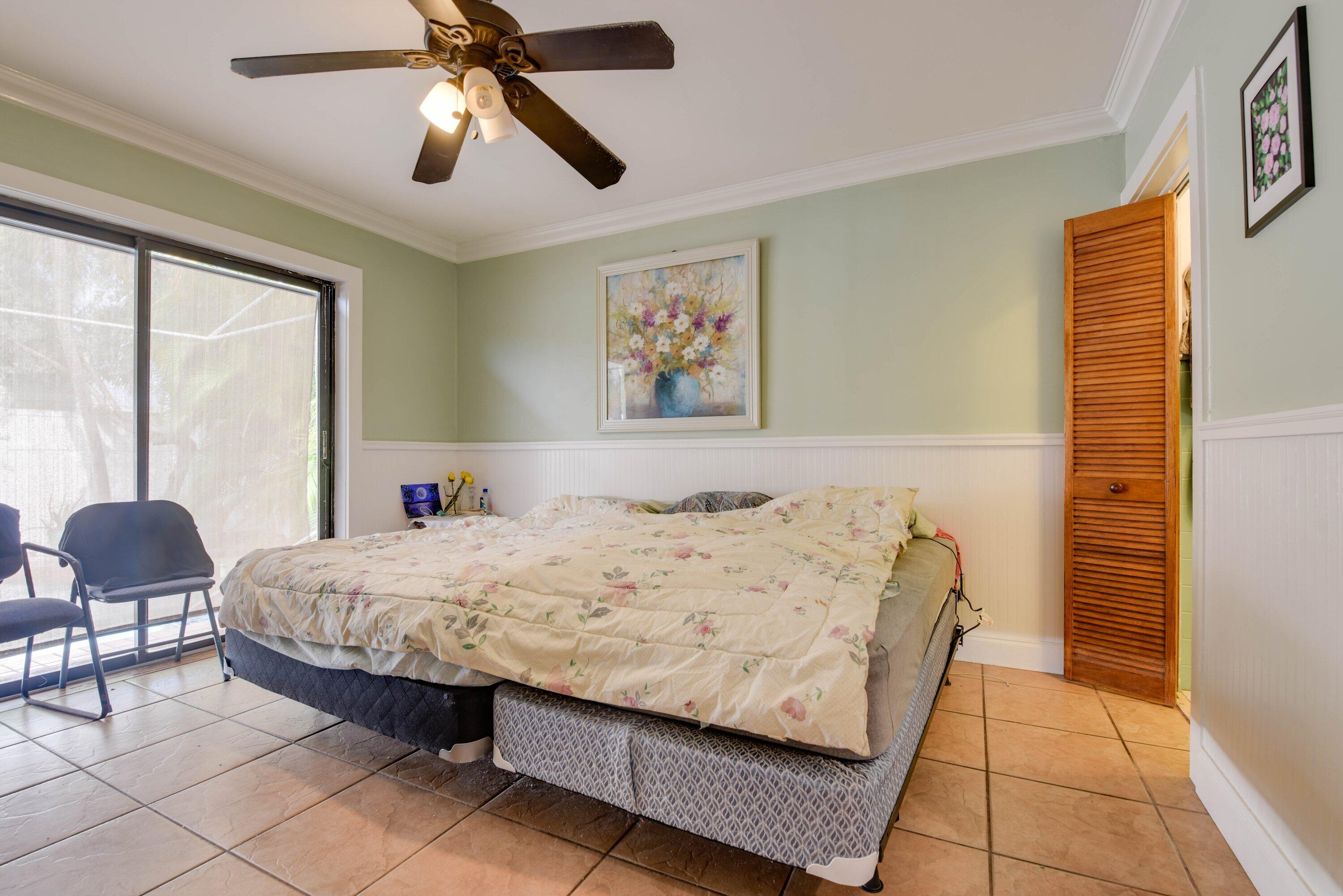 3421 Riviera Drive Key West, FL 33040 - Photo 13 of 32 a bedroom with a bed and a chandelier