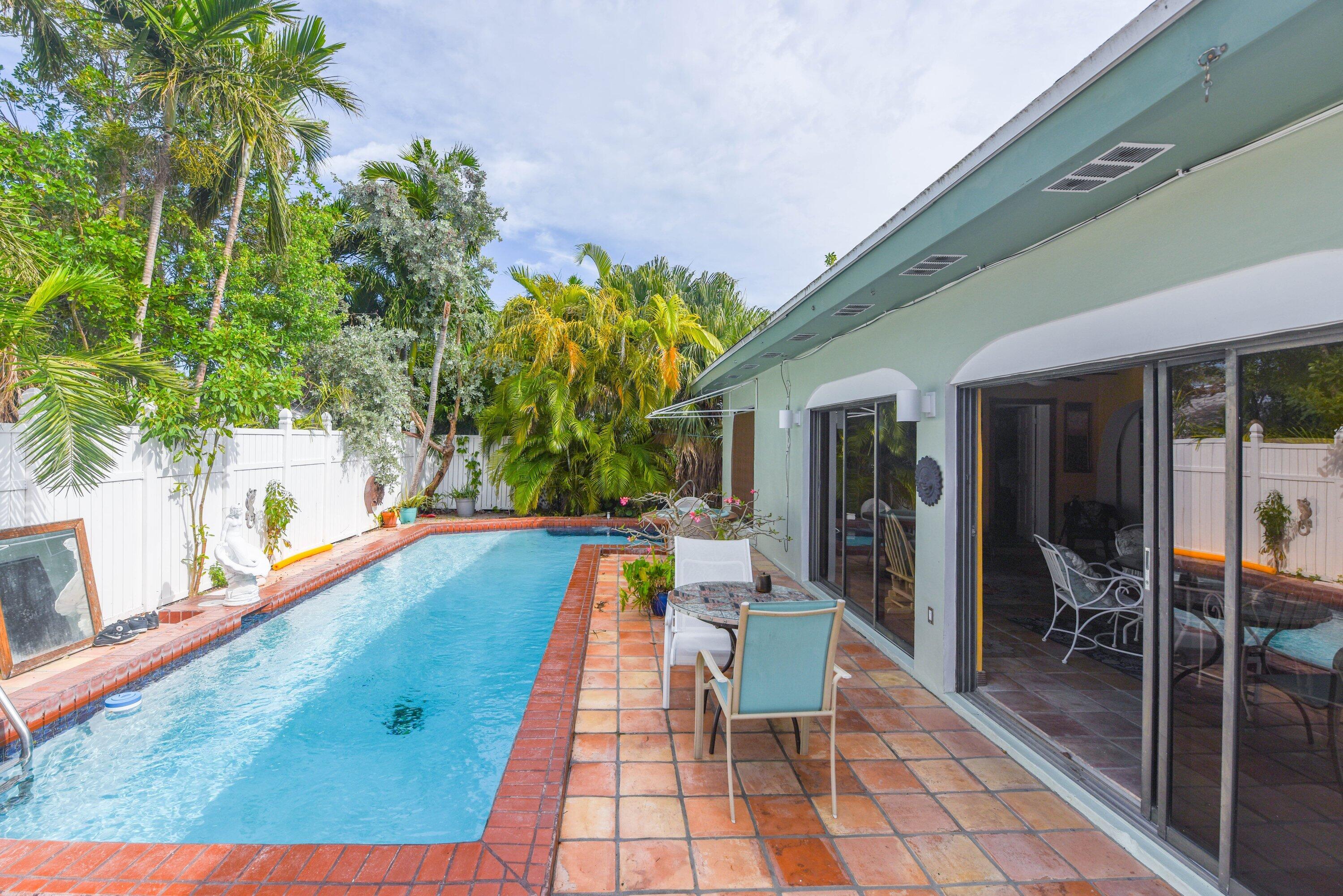 3421 Riviera Drive Key West, FL 33040 - Photo 24 of 32 a view of a patio with dining table and chairs with plants and wooden floor