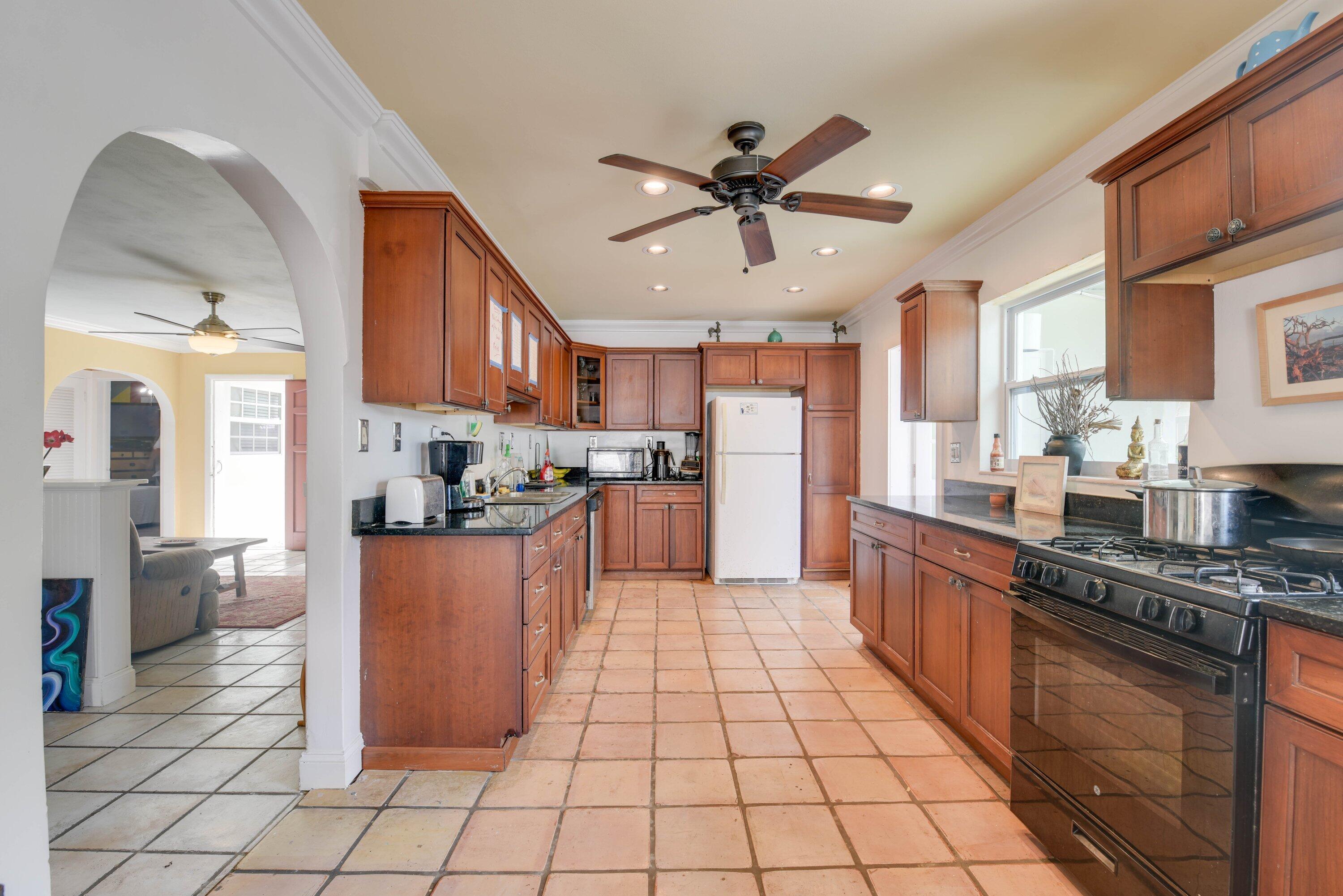 3421 Riviera Drive Key West, FL 33040 - Photo 9 of 32 a kitchen with stainless steel appliances granite countertop a stove top oven a sink a counter space and cabinets