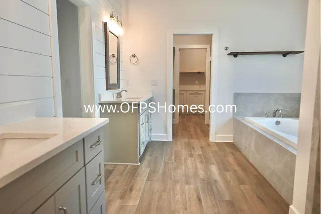 a spacious bathroom with a tub sink and mirror