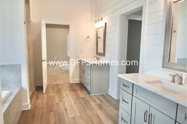 a spacious bathroom with a sink a mirror and a shower