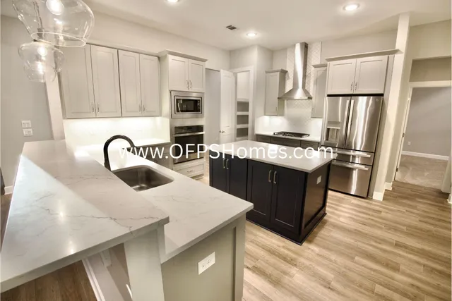 a kitchen with kitchen island stainless steel appliances a sink and a counter top space