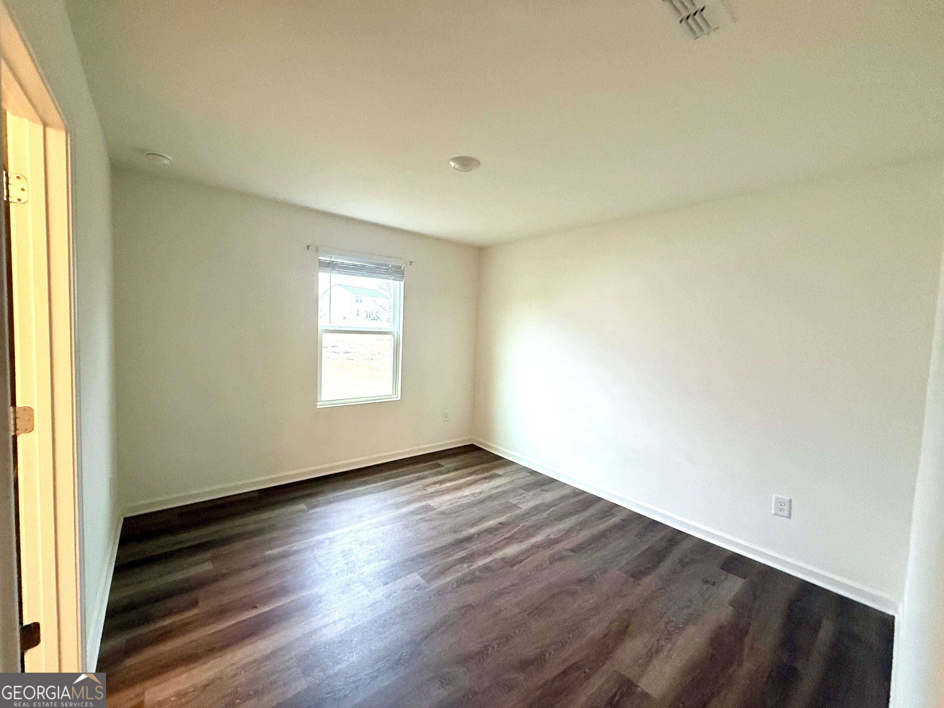119 Pond Court Hoschton, GA 30548 - Photo 23 of 29 an empty room with wooden floor and windows