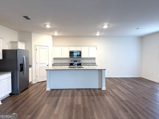 a view of kitchen with wooden floor and electronic appliances