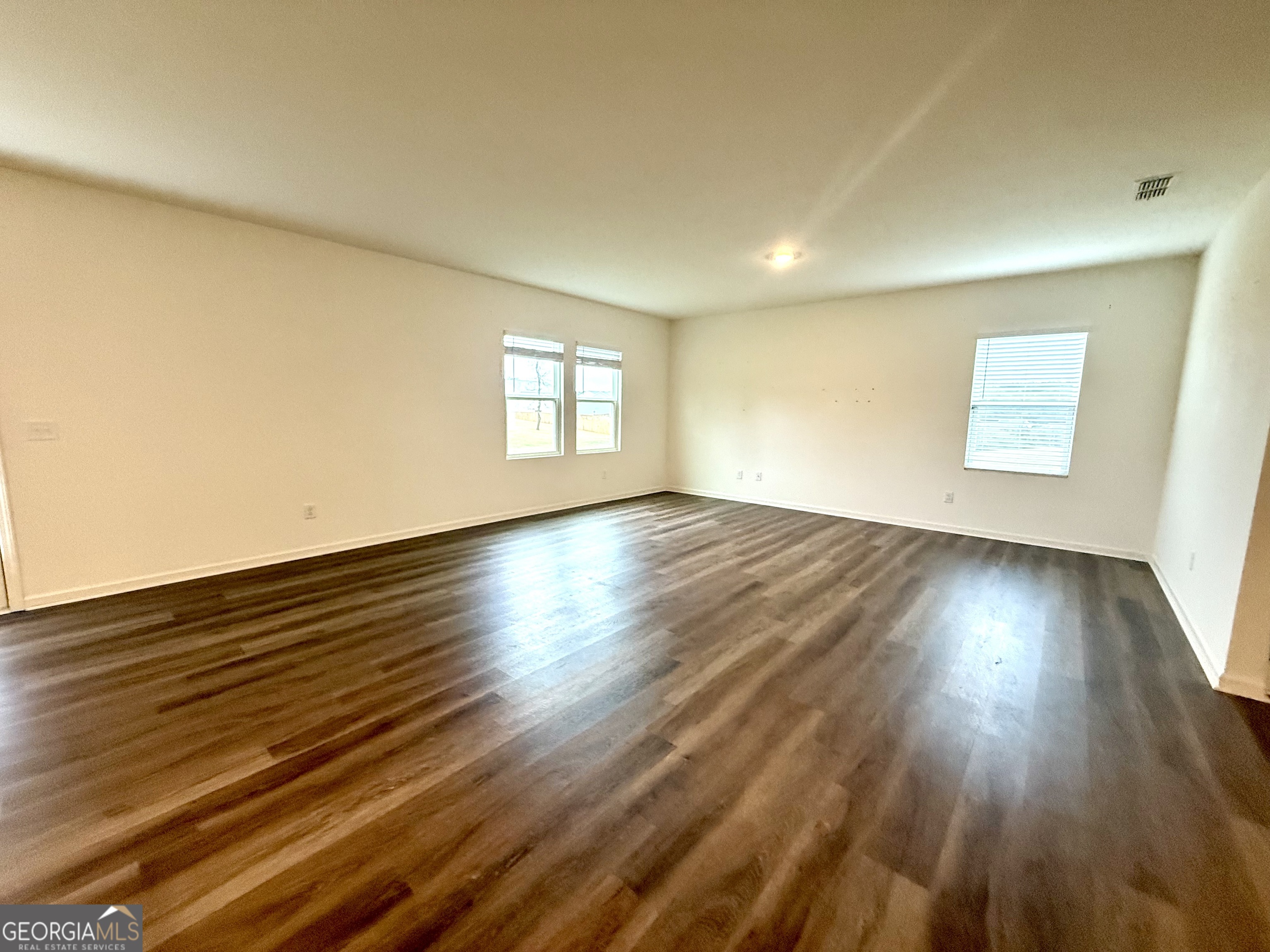 119 Pond Court Hoschton, GA 30548 - Photo 7 of 29 a view of an empty room with wooden floor and a window