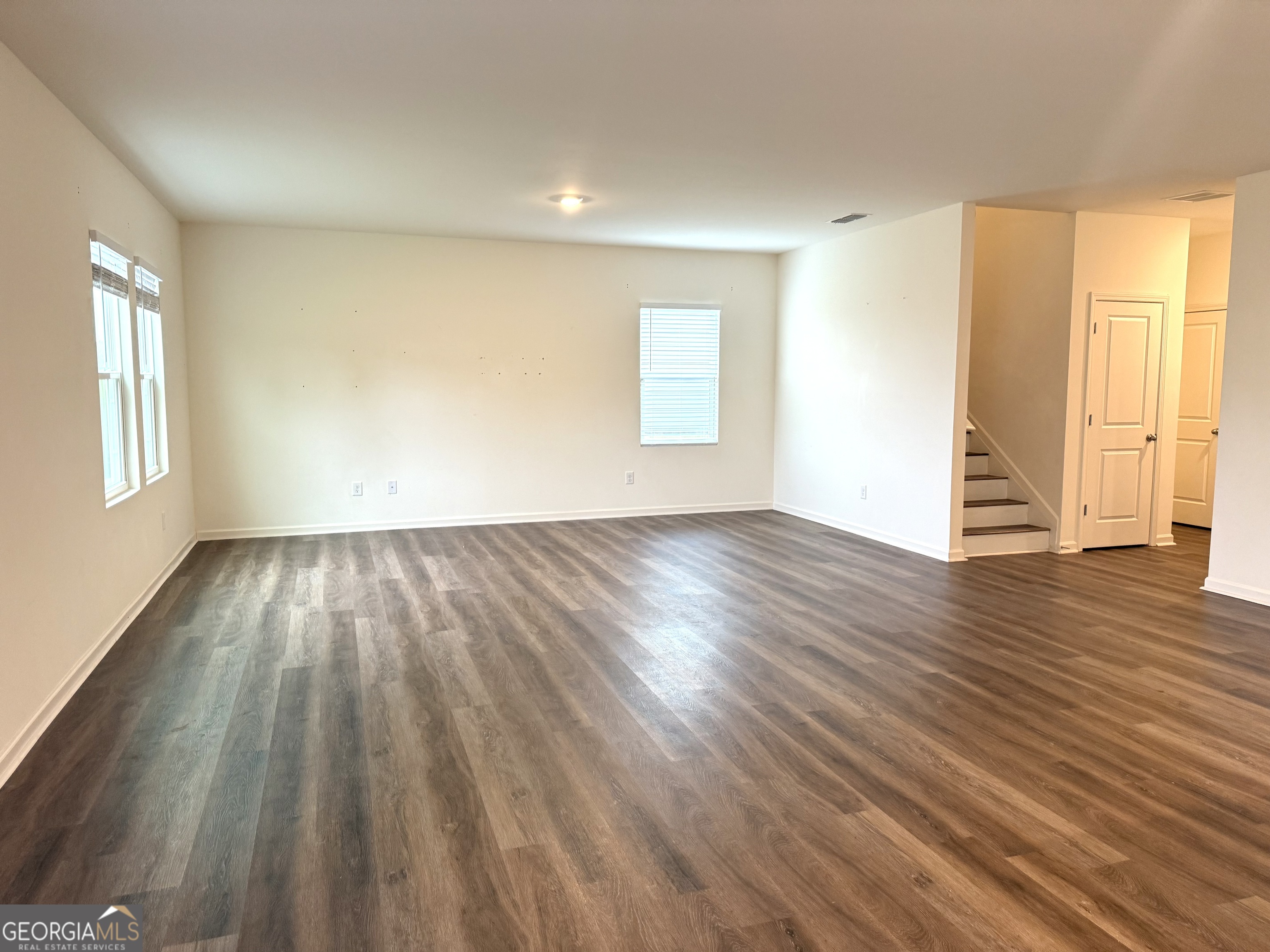 119 Pond Court Hoschton, GA 30548 - Photo 8 of 29 an empty room with wooden floor and windows