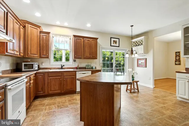 a kitchen with stainless steel appliances granite countertop a sink a stove and a refrigerator