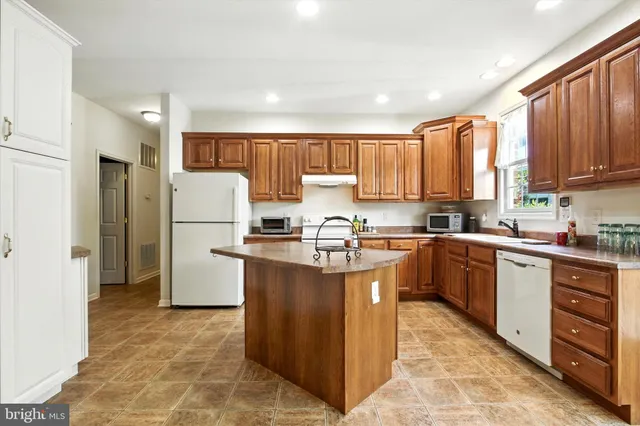 a kitchen with stainless steel appliances granite countertop a refrigerator sink and cabinets