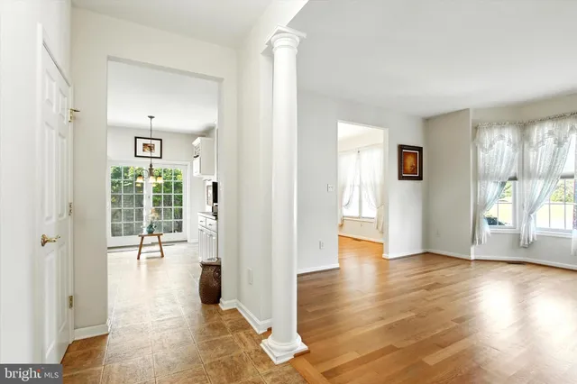 a view of a hallway with wooden floor and a living room