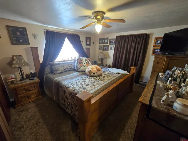 a bed sitting in a bedroom next to a window with pc on the table