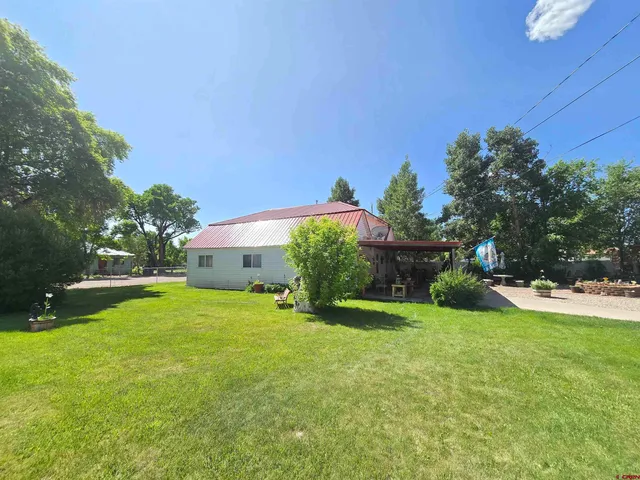 a view of a house with a yard and a porch