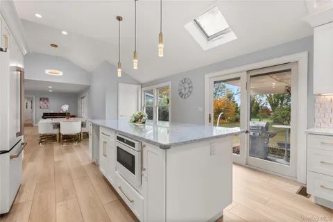 a kitchen with stainless steel appliances granite countertop a stove and a wooden floors