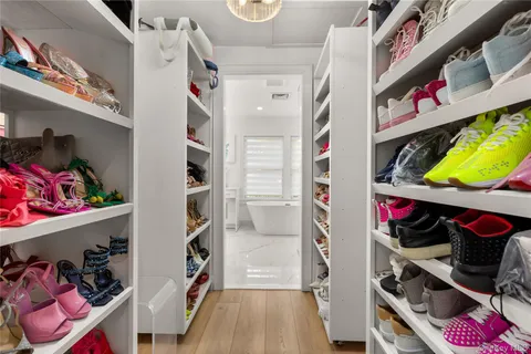a view of walk in closet with clothes and shoes